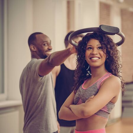 Group of happy multinational people exercising in gym using resistance ringの写真素材