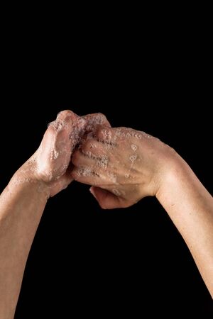 Kid washing hands with soap to stop spreading virus infection, on black background