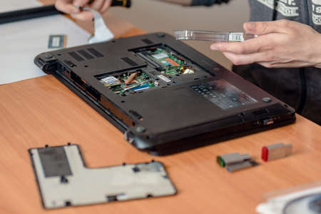 Dnepr, Ukraine- May 04, 2020: Technician reparing broken computer and installing new ssd diskのeditorial素材