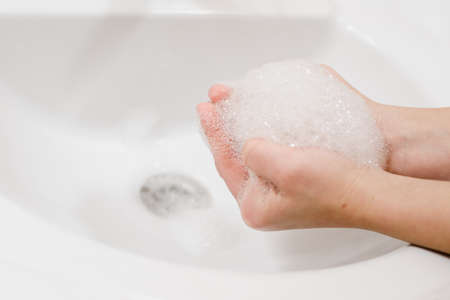 Closeup photo of kid holding soap foam in handsの写真素材