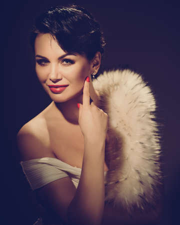 Retro portrait of beautiful luxury woman in stylish dress showing naked shoulder. retro style toned imageの写真素材