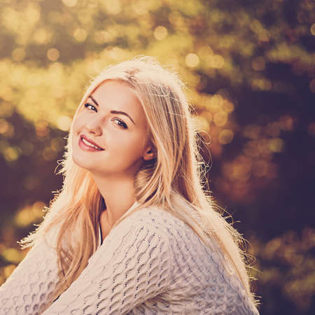 Portrait of beautiful young blonde on the background of yellow foliage