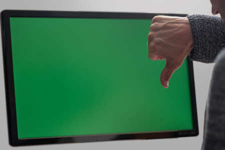 Man gesturing thumb down on the background of green screenの写真素材