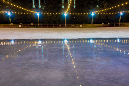 Empty ice rink with bright christmas decoration and lightsの写真素材