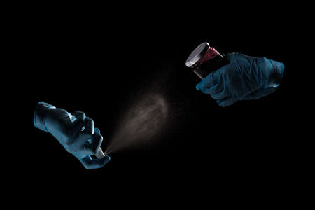 Hands in medical gloves using sanitizer for desinfection jar of jamの写真素材
