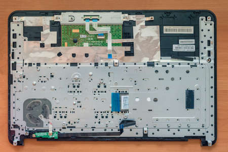 Dnepr, Ukraine- May 04, 2020: Disassembled old laptop on repairman workplace, top view photo