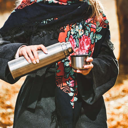 close up of woman with  tea in autumn park on sunny dayの写真素材