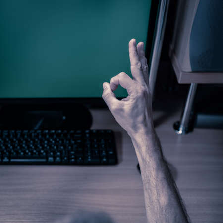 Mans hands with credit card gesturing like against green chromakey computer screenの写真素材