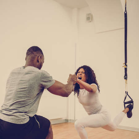 Two young multiethnic man and woman doing resistance exercise together