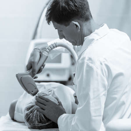 ELOS lifting procedure is safe and effective skin tightening therapy. black and white image with blue tint to emphasize the concept of high technologyの写真素材