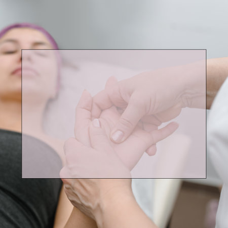 Professional masseur doing hands massage for young woman in beauty salon, with field for ad textの写真素材