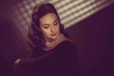 Portrait of young beautiful elegant woman wearing pearls. image toned in warm colors in retro style