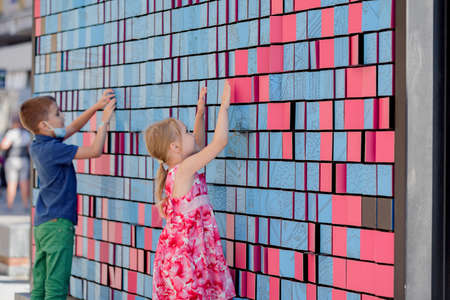 Dnepr, Ukraine- September 12, 2020: Happy excited kids having fun with pixels on big bright wall, violations of quarantine measures, children and a pandemic, entertainment at the city siteのeditorial素材