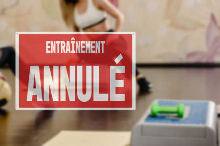 in French inscription sorry workout canceled. training cancellation due to business closure. Closeup of healthy sporty woman training with step platformの写真素材