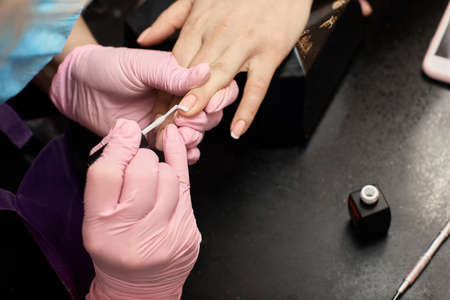 Manicurist making luxury french nail design on beautiful female hands, hand care, sterility, safety of the procedureの写真素材