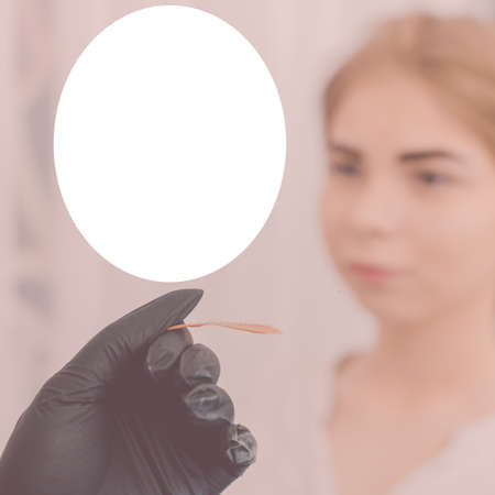 Beauty master doing henna eyebrow coloring in beauty salon, with field for ad textの写真素材