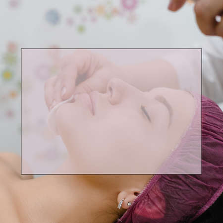Top view of cosmetologist removing peeling mask from female face