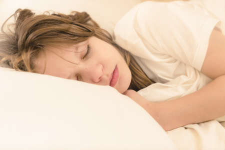 Portrait of calm male kid sleeping on soft comfortable pillow. difficulty waking up on timeの写真素材