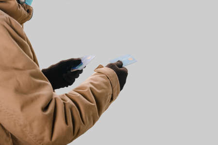 Closeup of man holding plastic credit cards on gray backgroundの写真素材
