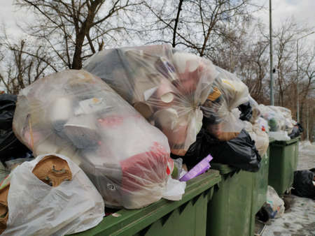 Dnepr, Ukraine- December 28, 2020: Big metal dumpster garbage can full of litter polluting city streetのeditorial素材