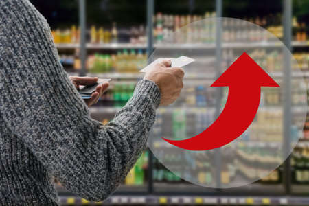 Young male customer making payment with credit card in grocery shop. the arrow shows the rise in valueの写真素材