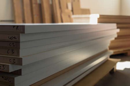 Closeup photo of stacked wooden boards in woodworking industryの写真素材