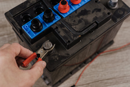 Closeup hand of auto mechanic checking car battery