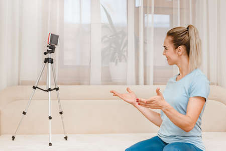 Happy young fitness instructor talking with clients through video call, Communication through...