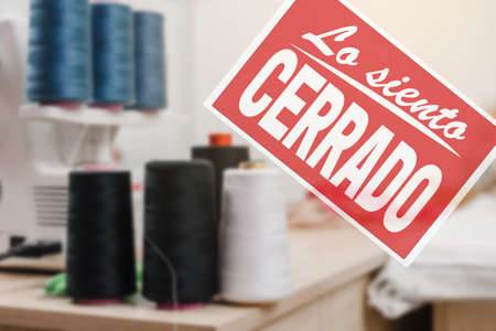 sorry we are closed inscription in spanish. Sorry we are closed sign on the background of clothing atelierの写真素材