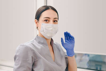 Portrait of female beautician doctor in spa salon wearing protective mask and glovesの写真素材