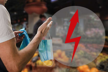 Male customer with protective medical mask and gloves while shopping in supermarket. arrow pointer...