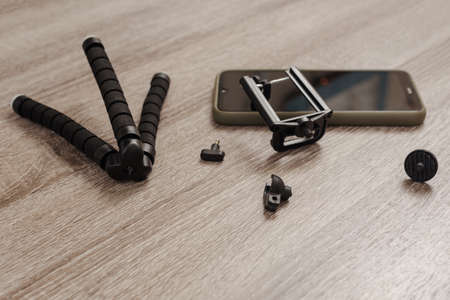 Closeup photo of deteriorated camera support and mobile phone lying on table