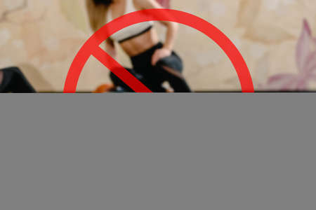 prohibition sign of going to the gym for social distancing. Closeup of healthy sporty woman training with step platformの写真素材