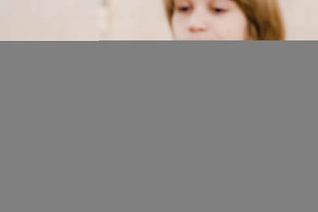 Blurred photo of handsome smiling young boy with toothbrush in hand. focus on toothbrushの写真素材