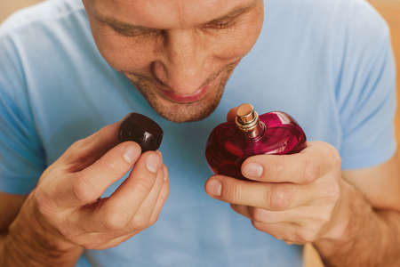 Portrait of excited happy man healing after disease smelling perfumeの写真素材