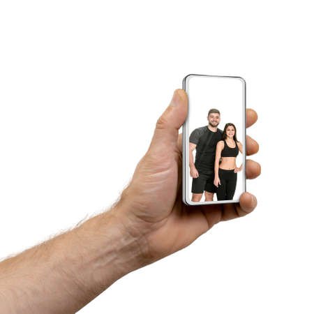 Having video call on cell phone technology device, online fitness app conceptの写真素材
