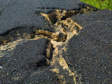 Close up photo of cracked ground with a ditch caused by continued rainの写真素材