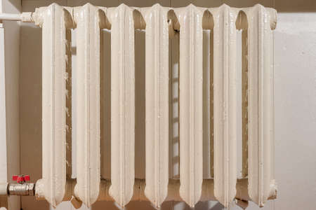 Old cast iron heating radiator connected to central system