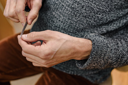 Closeup photo of man doing manicure himself at home, time for yourself men