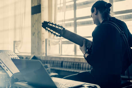 Male artist guitarist working with audio in music recording studioの写真素材