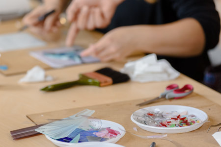 Closeup of woman arranging mosaic pieces in colorful ornamental imageの写真素材