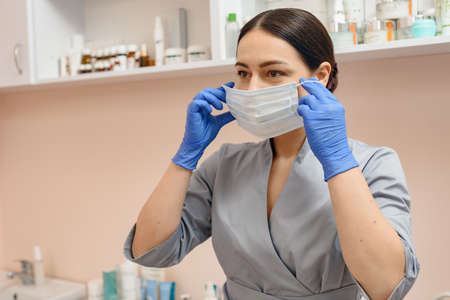 Portrait of young female doctor in medical uniform and face maskの写真素材