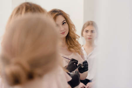 Young woman doing eyebrows correction procedure in modern beauty salonの写真素材