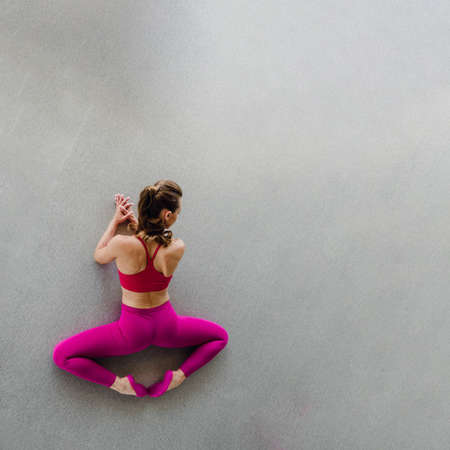 Top view of slim young woman stretching muscles and doing frog exerciseの写真素材