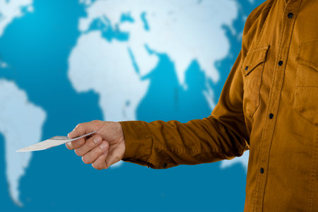 Male tourists hand holding boarding pass during registration for departure
