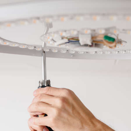 fixing the ceiling LED lamp on the screw to the ceiling
