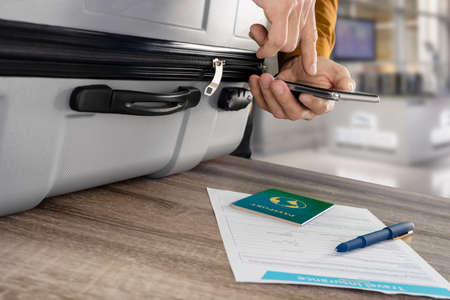 Male tourist booking travel insurance to avoid baggage lostの写真素材