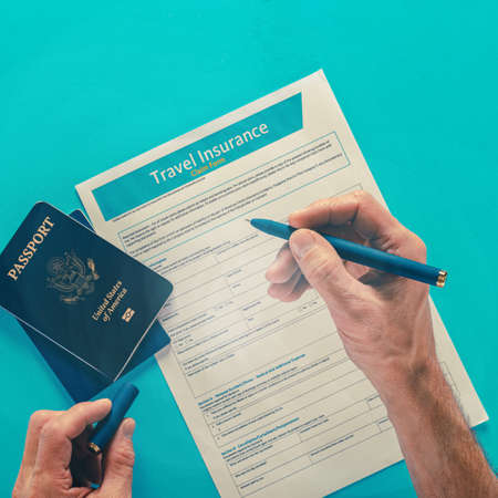 Male tourist with USA passport man signing travel insurance policyの写真素材