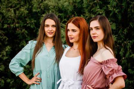 Three young beautiful smiling women posing in trendy summer dressesの写真素材