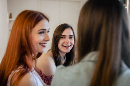 Group of attractive emotional girls meeting in cafe, smiling and laughing togetherの写真素材